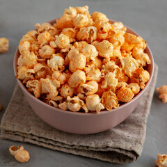 Homemade Cheese Popcorn in a Bowl on a gray background, side view.