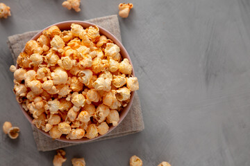 Homemade Cheese Popcorn in a Bowl on a gray background, top view.