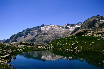 Naklejka na ściany i meble A pristine high mountain lake reflects the majestic beauty of a mountain range