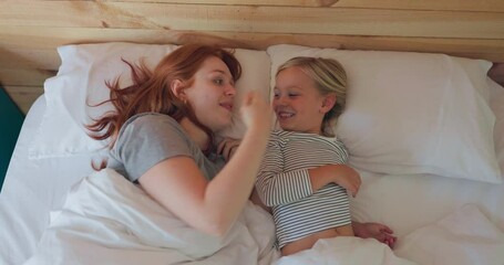 Bed, wake up and a mother kissing her daughter in the morning after sleeping in their home together. Smile, relax or early with a woman and girl child lying in a bedroom for bonding over the weekend