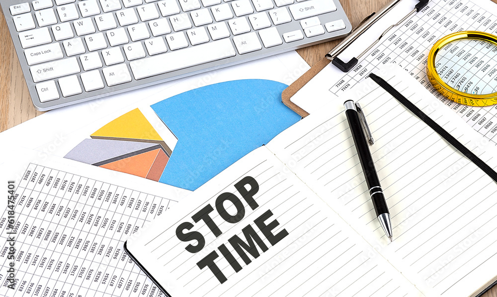 Poster stop time text on notebook with chart and keyboard