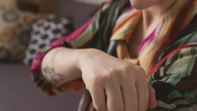 Closeup of unrecognizable girl adjusting modern robotic arm prosthesis indoors