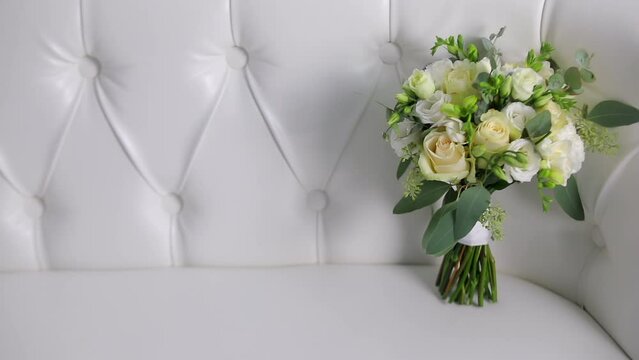 Beautiful modern wedding bouquet. Bouquet of fresh roses. Wedding Bouquet staying on a sofa. Flowers Arrangement with a Roses.
