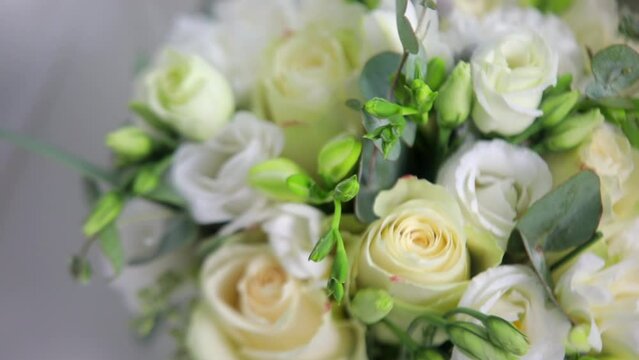 Close up of The Bridal Bouquet. Beautiful modern wedding bouquet of fresh white roses staying on a sofa. Flowers Arrangement with a Roses.