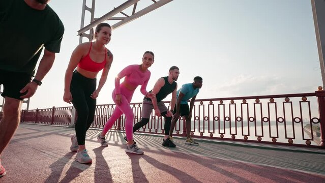 Male and female runners stand in row preparing to run