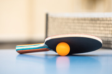 Table tennis. Blue ping pong table. Ping pong racket and ball. The concept of sport and healthy...