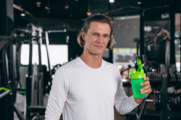 healthy sport man with whey shaker bottle. happy drinking whey protein for muscle strength mass...