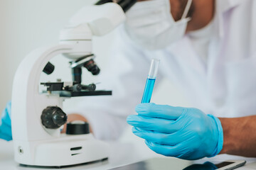 Fototapeta premium Medical science laboratory: Portrait of a scientist looking under a microscope analyzing a test sample. Works with advanced devices