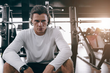 serious sport athlete man fitness trainer sitting in sport club gym body muscle training people
