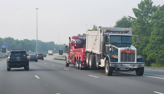 Wilmington, Delaware, U.S.A - June 29, 2023 - A tow vehicle carrying a large truck on Interstate 95 North