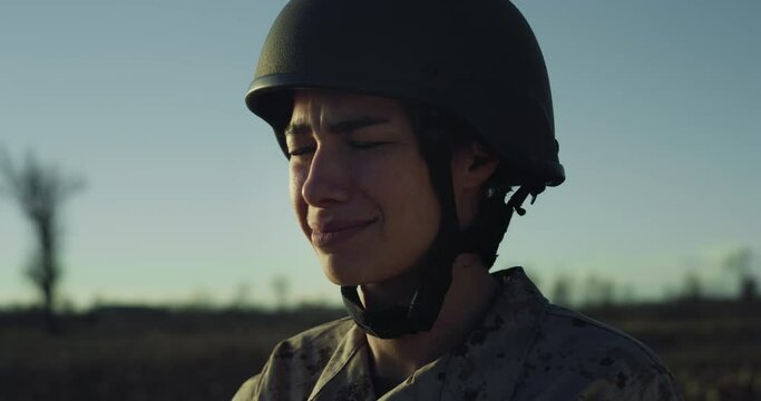 Slow Motion Close Up Portrait of Young Female Soldier Looking at the Horizon and Crying in a Field During Sunset. Woman in Camouflage Military Uniform Having Emotional Distress, Missing her Family