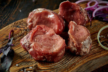 Marinated fresh pork tenderloin with spices on a wooden board