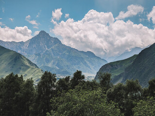 Rocky peak and white clouds in summer