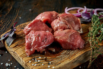 Marinated fresh pork tenderloin with spices on a wooden board