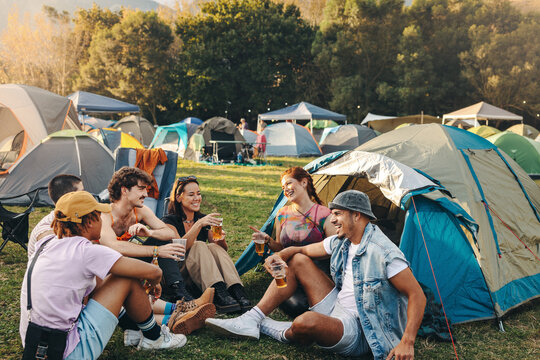 Festival camp conversations: Group of youthful friends bond over beer and laughter