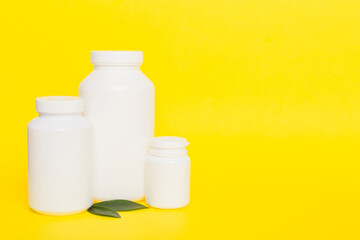 supplement pills with medicine bottle health care and medical top view. Vitamin tablets. Top view mockup bottle for pills and vitamins with green leaves, natural organic bio supplement, copy space