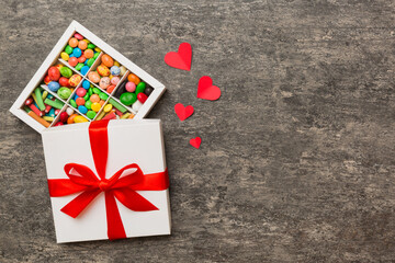 Valentine day composition: sweet candy, with gift boxes with bow and red felt hearts, photo template, background. Top View with copy space