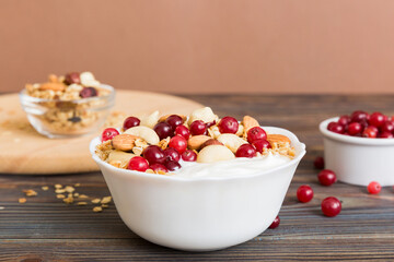Healthy breakfast food with granola, yogurt, fruits and nuts. Dessert parfait with dried fruits for breakfast