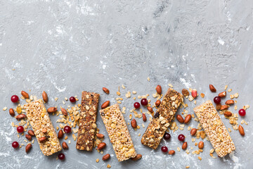 Various granola bars on table background. Cereal granola bars. Superfood breakfast bars with oats, nuts and berries, close up. Superfood concept