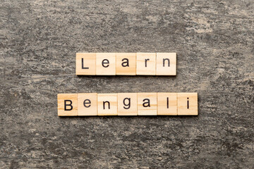 learn Bengali word written on wood block. learn Bengali text on table, concept