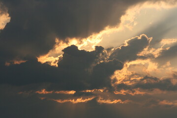 sun shining behind the clouds