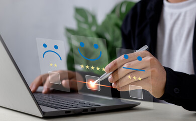 Businessman touching the virtual screen on the happy Smiley face icon to give satisfaction in service. Customer service and Satisfaction concept, rating very impressed..