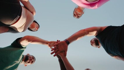 People bring hands together in unity gesture after workout