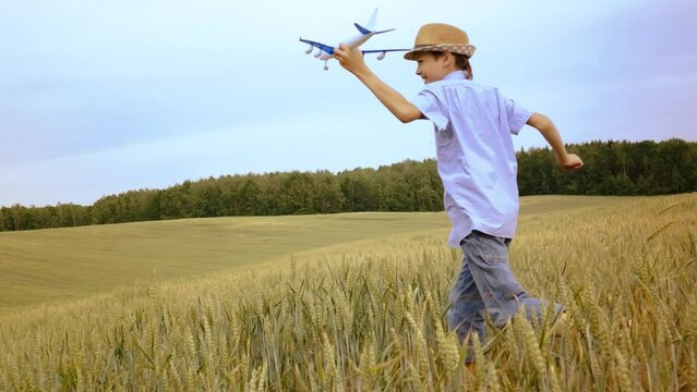 Euphoric Boy with Toy Airplane Soaring through Golden Wheat Fields on Hilltop