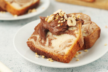 A piece of marble biscuit with chocolate cream and nuts