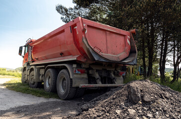 Dump truck at the construction site. Dumping truck or dumper lorry with box bed for transporting materials.