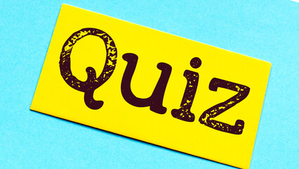Quiz time concept, word on a small piece of paper and a blue background.