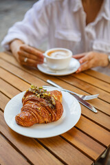 Breakfast with crunchy croissants and coffee on a terrace in the summer
