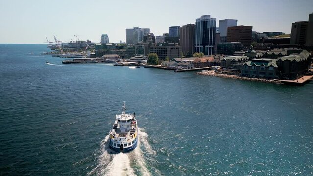 Drone Shot Forward Tracking City Water Transport Ferry Crossing Ocean From Dartmouth to Halifax Carrying passengers Modern City. Atlantic Ocean Buildings City center Embankment. Halifax, Canada.