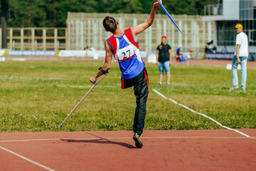 male athlete without leg with crutch javelin throw at athletics championships, summer sports games
