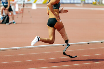 female para athlete on prosthetic leg running track stadium, summer para athletics championships