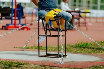 athlete without legs tied to table with belt shot put in para athletics, summer sports games