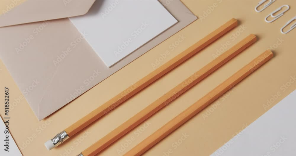 Poster flat lay of pencils, envelope and memo note with copy space on yellow background