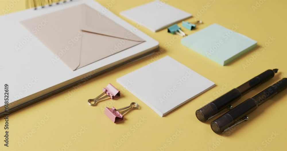 Poster flat lay of pens, envelope and memo notes with copy space on yellow background