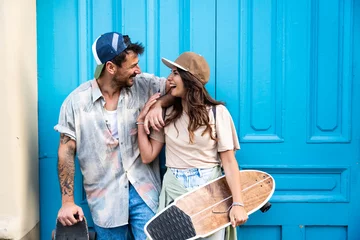 Foto op Plexiglas Portrait young couple with skateboard and longboard having fun outdoors. Man and woman skateboarders world travelers tourists in Mediterranean driving and skateboarding through touristic destinations © Srdjan