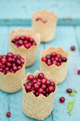 berry cranberries in small wicker baskets on a blue background