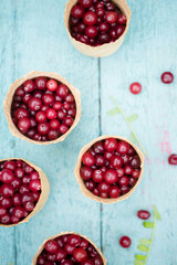 berry cranberries in small wicker baskets on a blue background