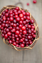 berry cranberries in a wooden basket on a wooden background