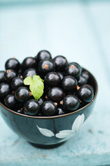 Ripe black currants on a blue background