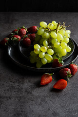 grape and strawberry on rustic plate
