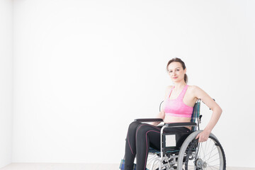 Naklejka na ściany i meble スポーツウェアを着て車椅子に乗る外国人の女性