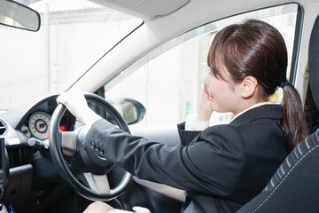 営業車で電話をするキャリアウーマン