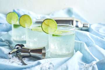 A freshly prepared gin and tonic with lemon slices and spoon on the table