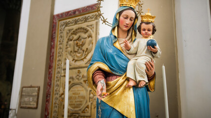 Obraz premium The Madonna with baby Jesus in her arms statue of a church