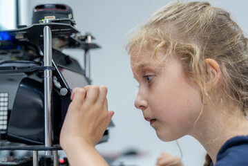 girl female teen children concentrate look Machine Learning Robot is Moving Under Control robot coding at technology stem class, stem education robot for digital automation artificial intelligence