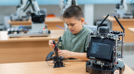 Fototapeta na wymiar Boy male teen child concentrate enjoy Machine Learning Robot is Moving Under Control robot coding at technology stem class, stem education robot for digital automation artificial intelligence ai